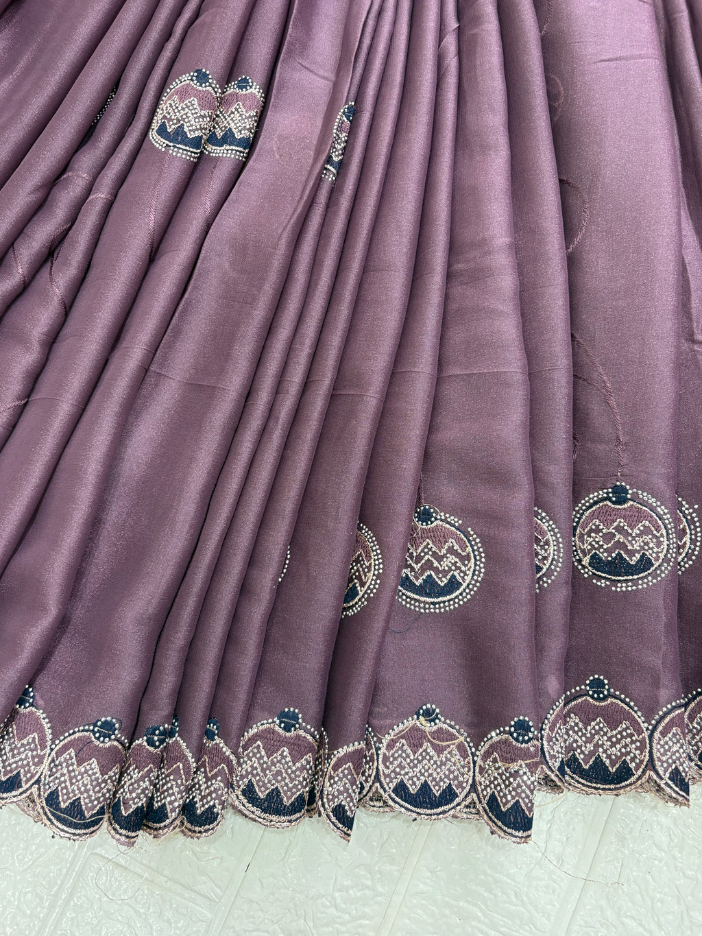 Saree Purple Embroidered Saree with purple mauve and georgette or organza Medallion Butti and Scalloped Border. It is a sheer saree with scattered embroidery and stonework.