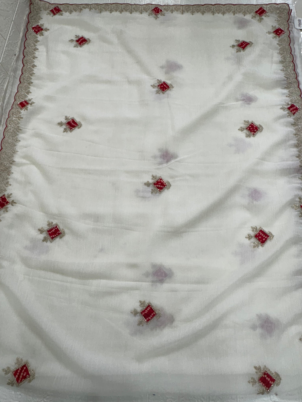 Name: Ivory Grace saree 
Elegant crush chinon fabric saree with red bandhej-style motifs and zari embroidered border. Bandhni-style blause fabric