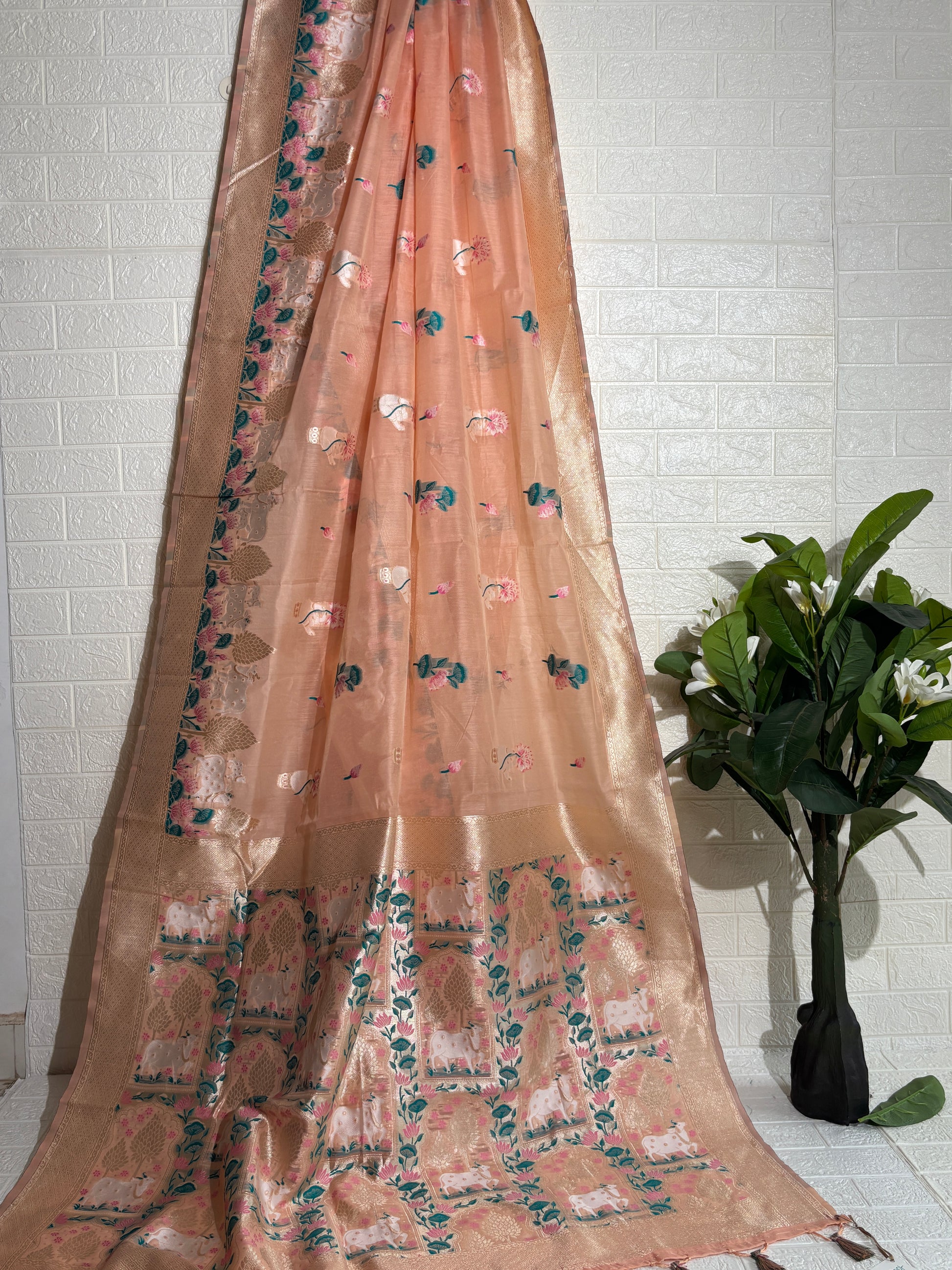 Woven Banarasi silk saree featuring traditional motifs of cows, trees, and floral elements