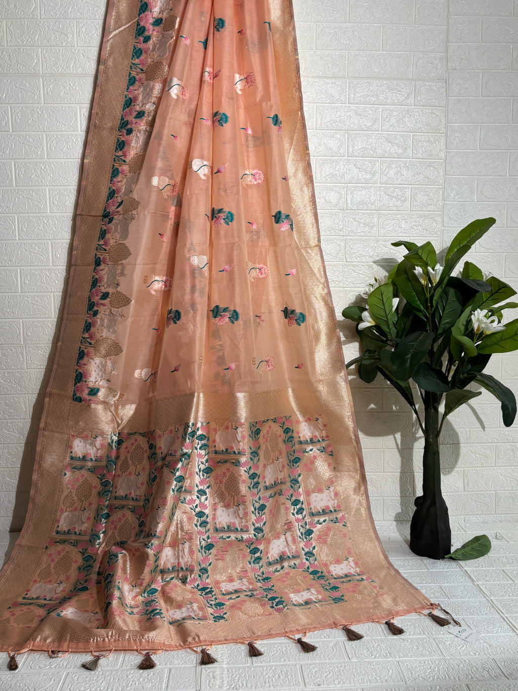 Woven Banarasi silk saree featuring traditional motifs of cows, trees, and floral elements