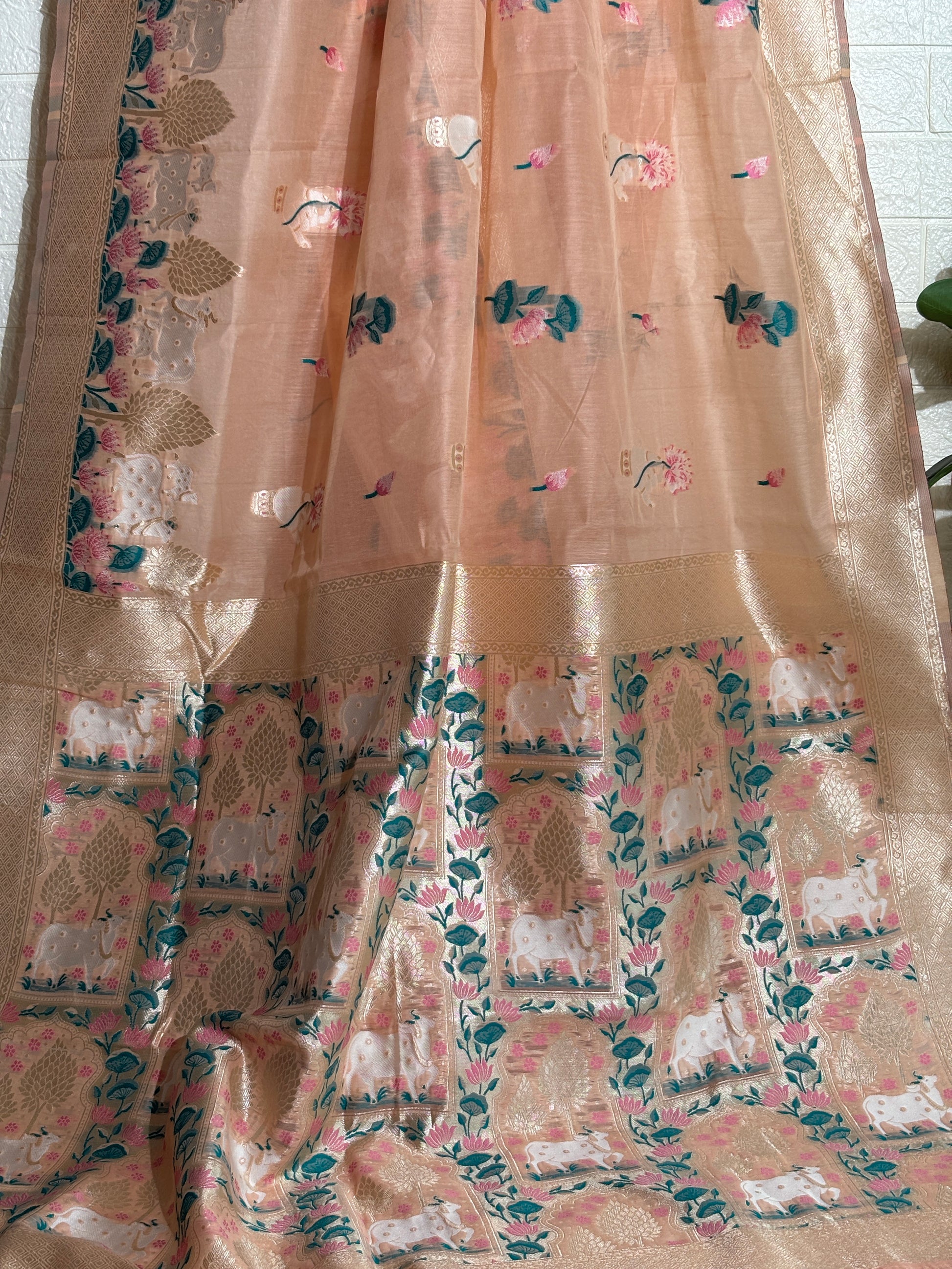 Woven Banarasi silk saree featuring traditional motifs of cows, trees, and floral elements